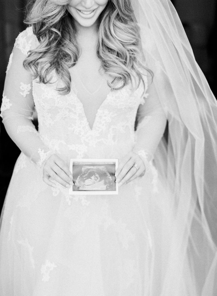 L'Auberge De Sedona Wedding -Bride in wedding dress holding pregnancy sonogram