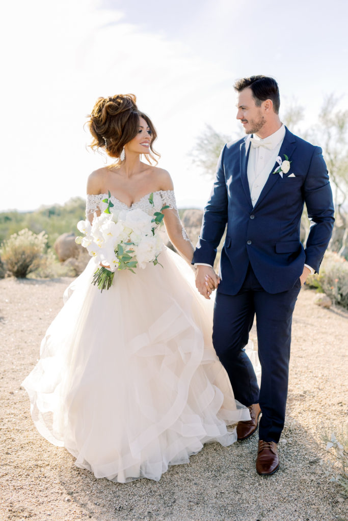 Bride and groom walking in the desert